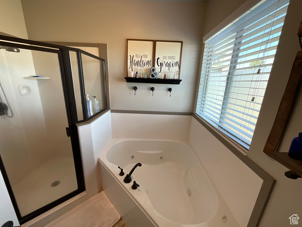 Bathroom with a shower stall and a whirlpool tub