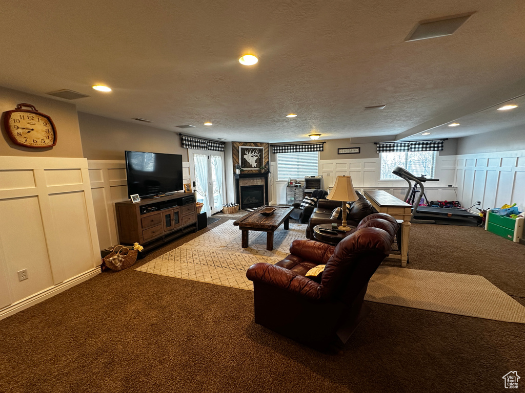 Living room with a wealth of natural light, a decorative wall, and carpet floors