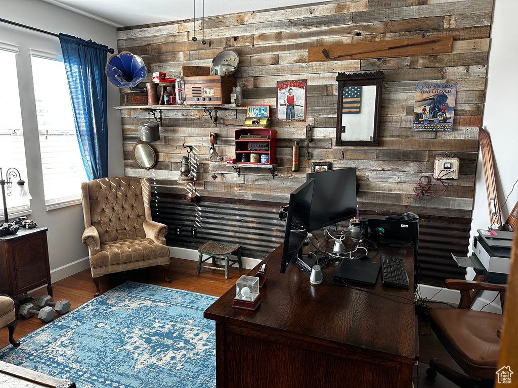 Office with bar, wood walls, baseboards, and wood finished floors