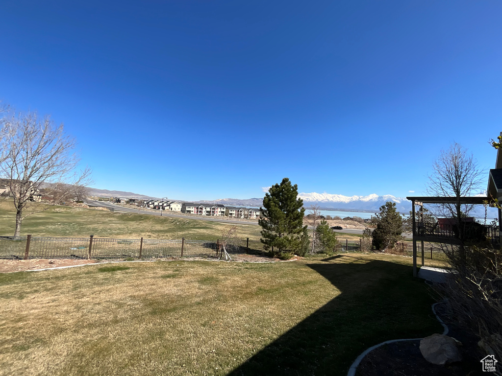 View of yard with a mountain view and fence