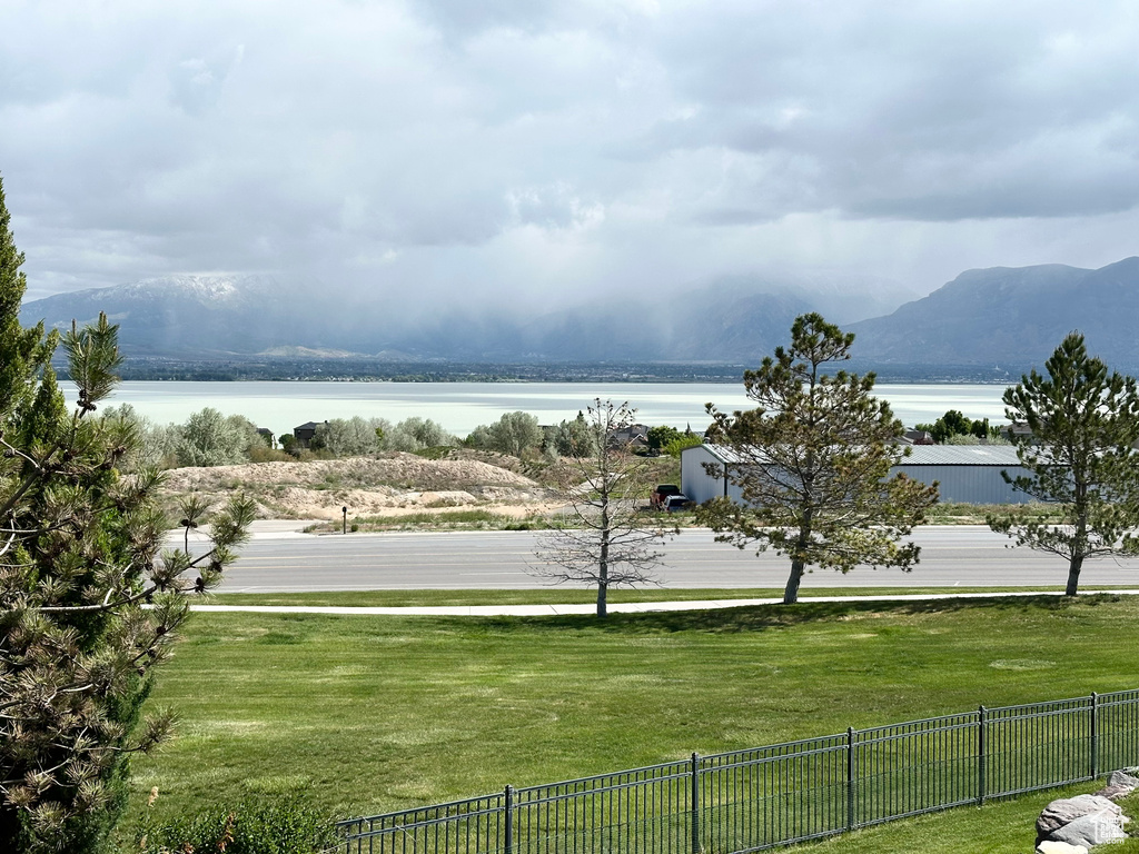 Water view with fence and a mountain backdrop
