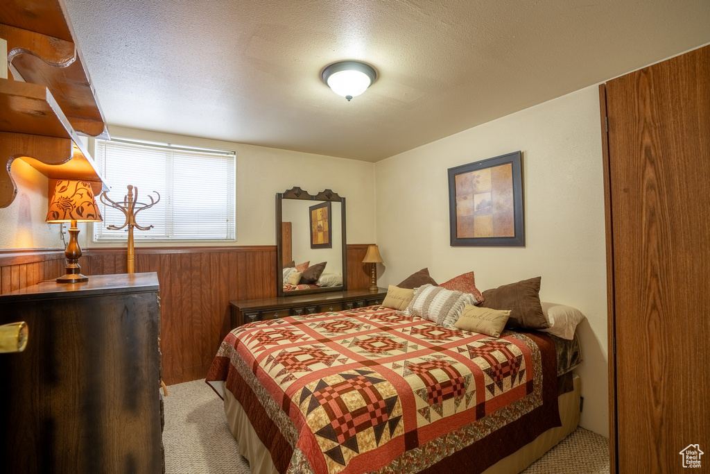 Bedroom featuring a wainscoted wall and wood walls