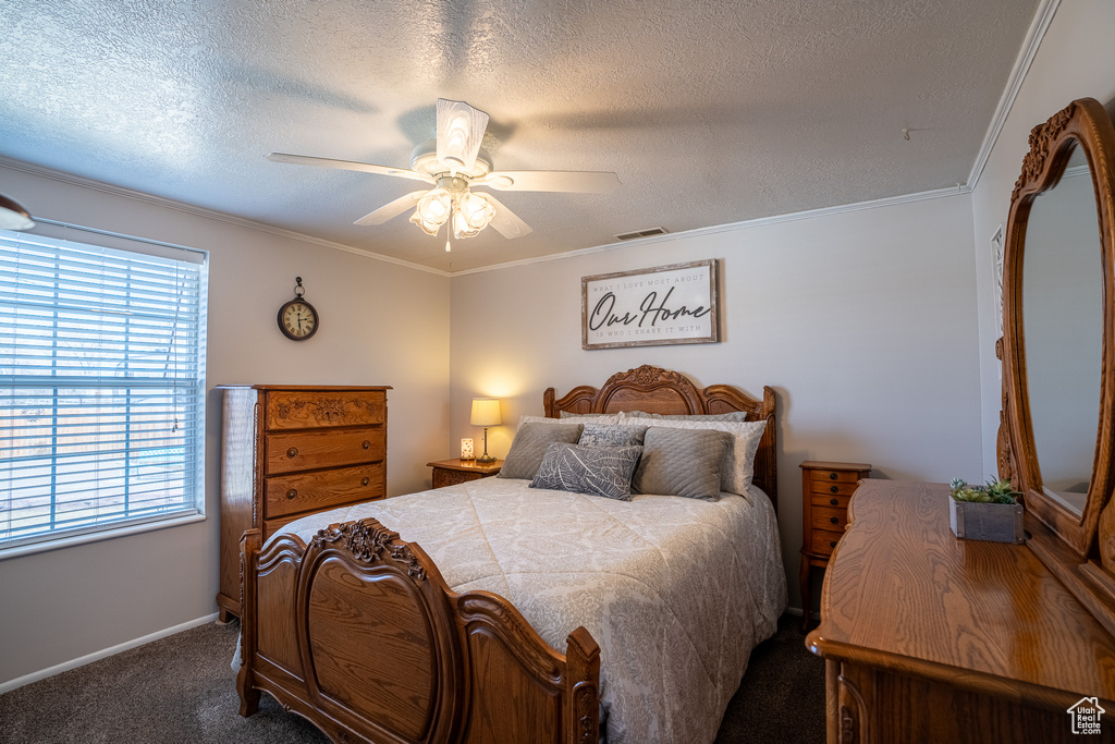 Bedroom featuring crown molding, carpet flooring, a ceiling fan, a textured ceiling, and visible vents