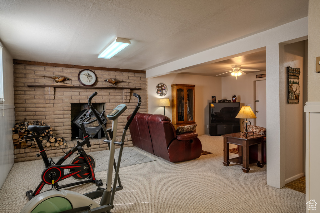 Workout area featuring a ceiling fan, carpet, and a wood stove