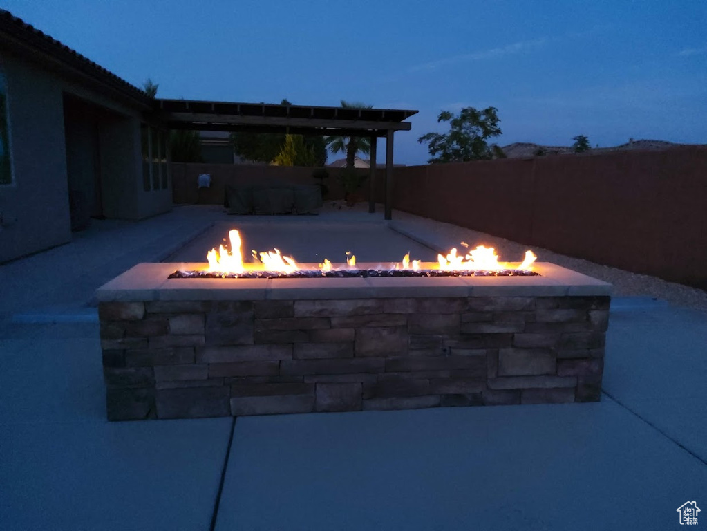View of patio with a fire pit and fence