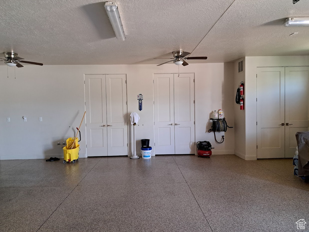 Garage featuring visible vents, baseboards, and ceiling fan