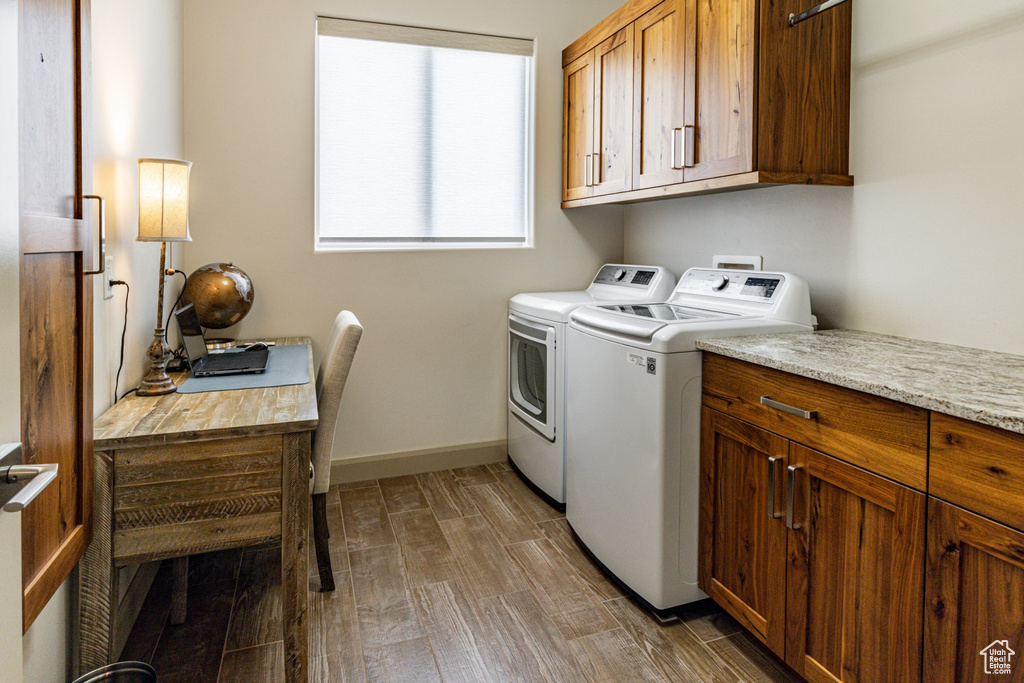 Laundry room with cabinet space, washing machine and dryer, baseboards, and wood tiled floor