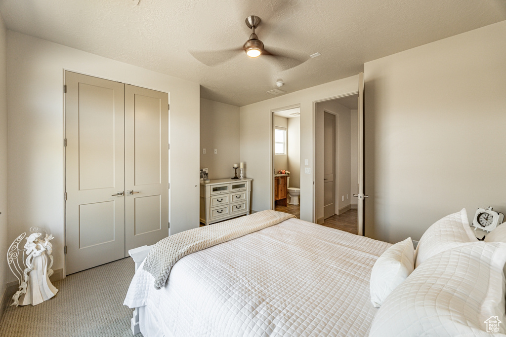 Bedroom featuring light carpet, a textured ceiling, a closet, and a ceiling fan