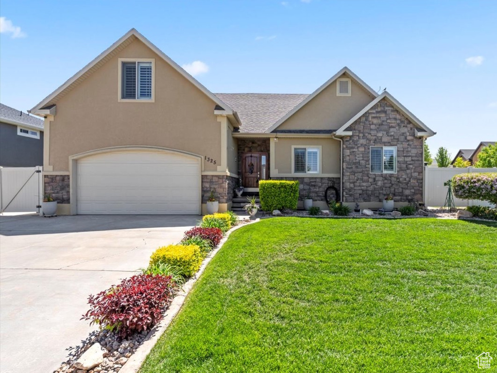 View of front facade with stone siding, stucco siding, concrete driveway, a gate, and roof with shingles