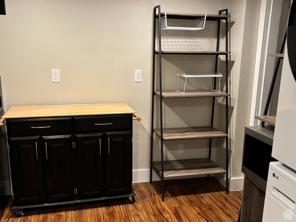 Finished basement featuring baseboards, stacked washer / dryer, recessed lighting, and dark wood-style flooring
