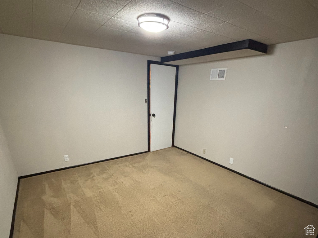 Unfurnished room featuring visible vents, a paneled ceiling, and light colored carpet