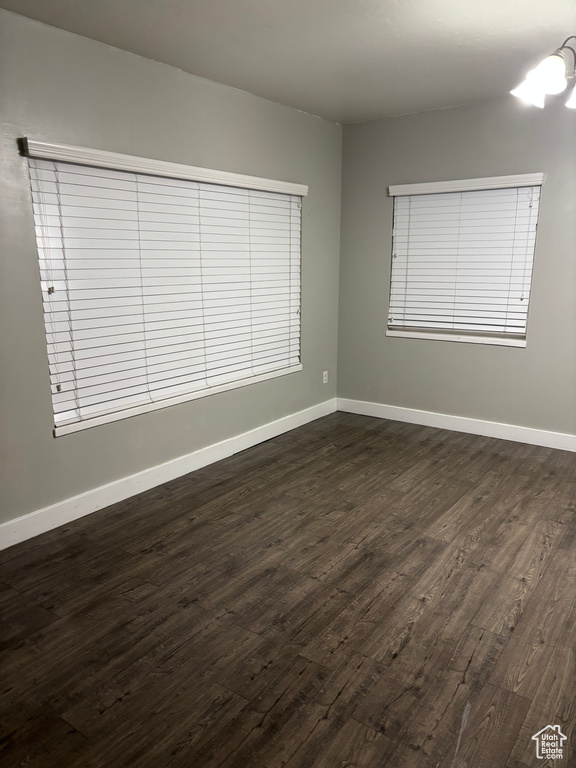 Empty room featuring dark wood-type flooring and baseboards
