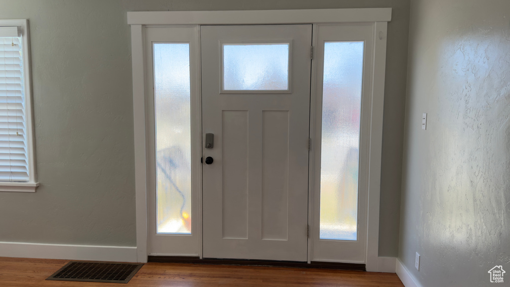 Foyer featuring baseboards, visible vents, and wood finished floors