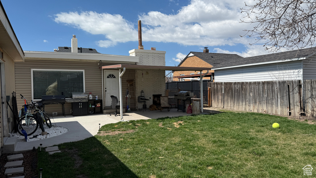 View of yard with fence and a patio area