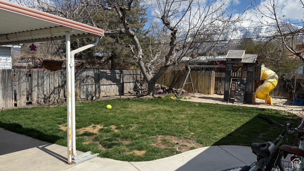 View of yard with a fenced backyard and a playground