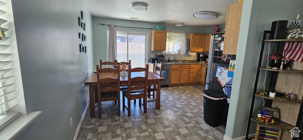 Kitchen with a sink, baseboards, light floors, and freestanding refrigerator