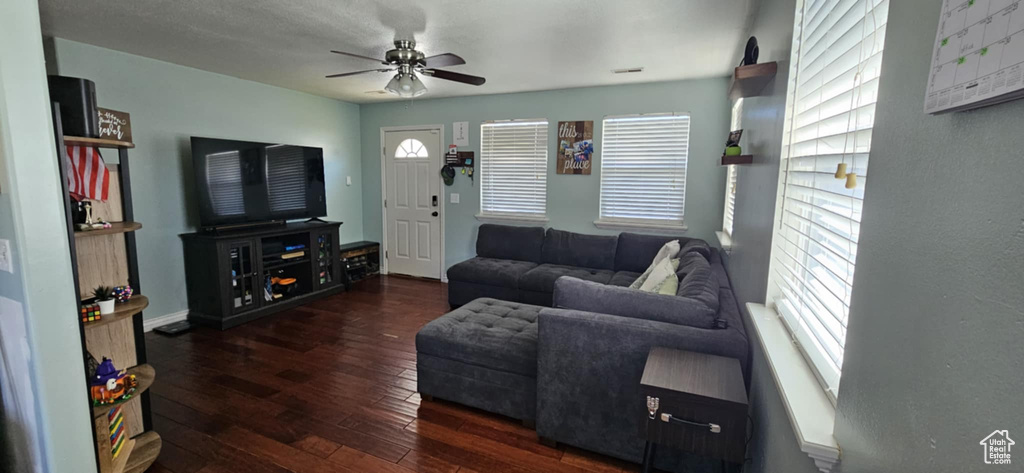 Living room with a ceiling fan and wood-type flooring