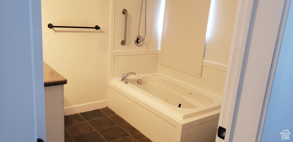 Full bathroom featuring baseboards, vanity, and tile patterned flooring