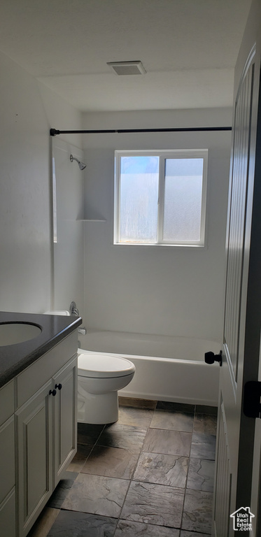 Bathroom with toilet, vanity, and  shower combination