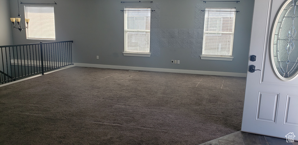 Carpeted entrance foyer featuring baseboards and healthy amount of natural light