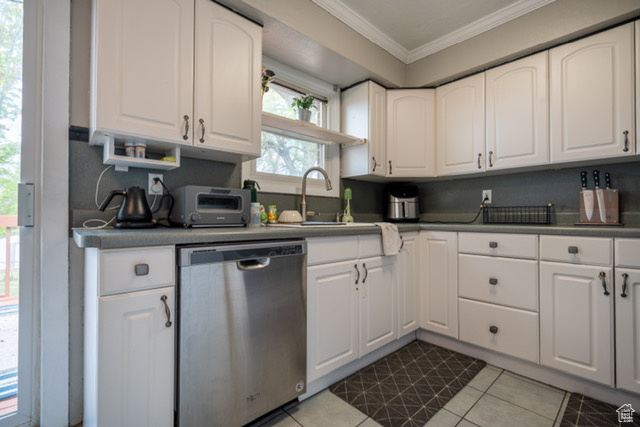 Kitchen with a sink, ornamental molding, stainless steel dishwasher, and white cabinets