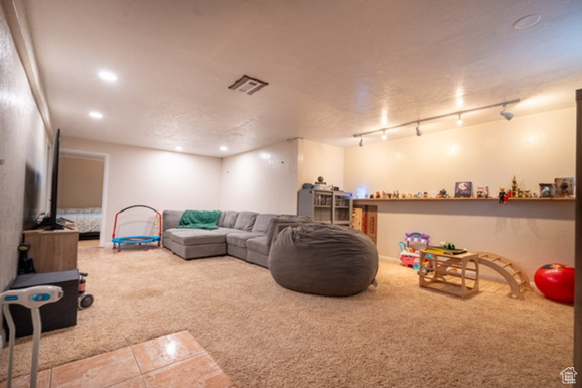 Carpeted living room featuring tile patterned flooring, recessed lighting, and visible vents