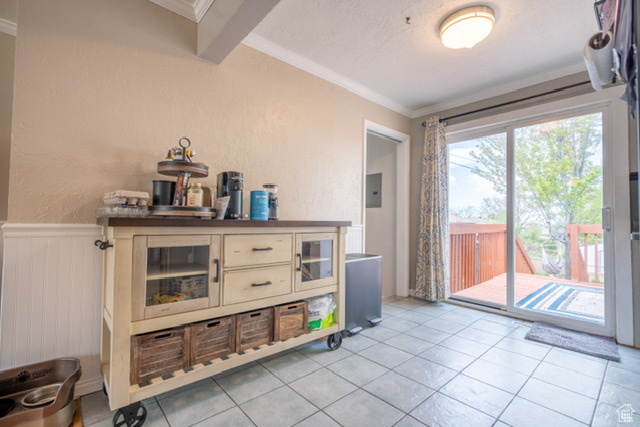 Entryway featuring crown molding, light tile patterned flooring, and electric panel