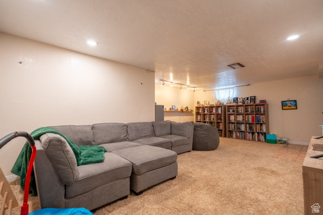 Carpeted living room with recessed lighting, visible vents, and track lighting