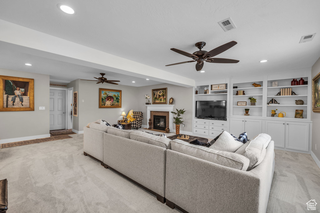Living area with light carpet, visible vents, and ceiling fan