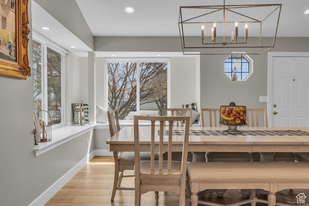 Dining area with light wood-style flooring, a notable chandelier, baseboards, and recessed lighting