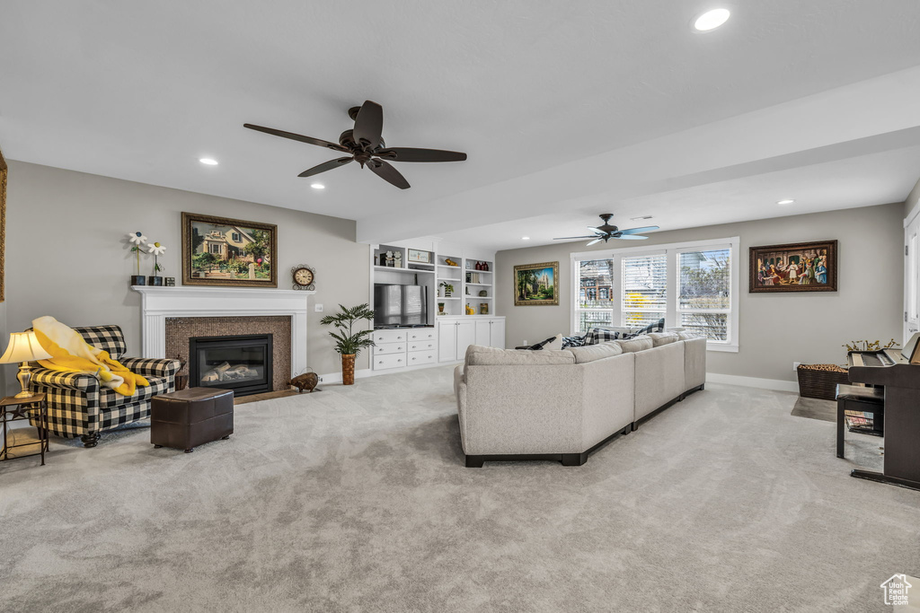 Carpeted living room featuring recessed lighting, a fireplace with flush hearth, baseboards, and a ceiling fan