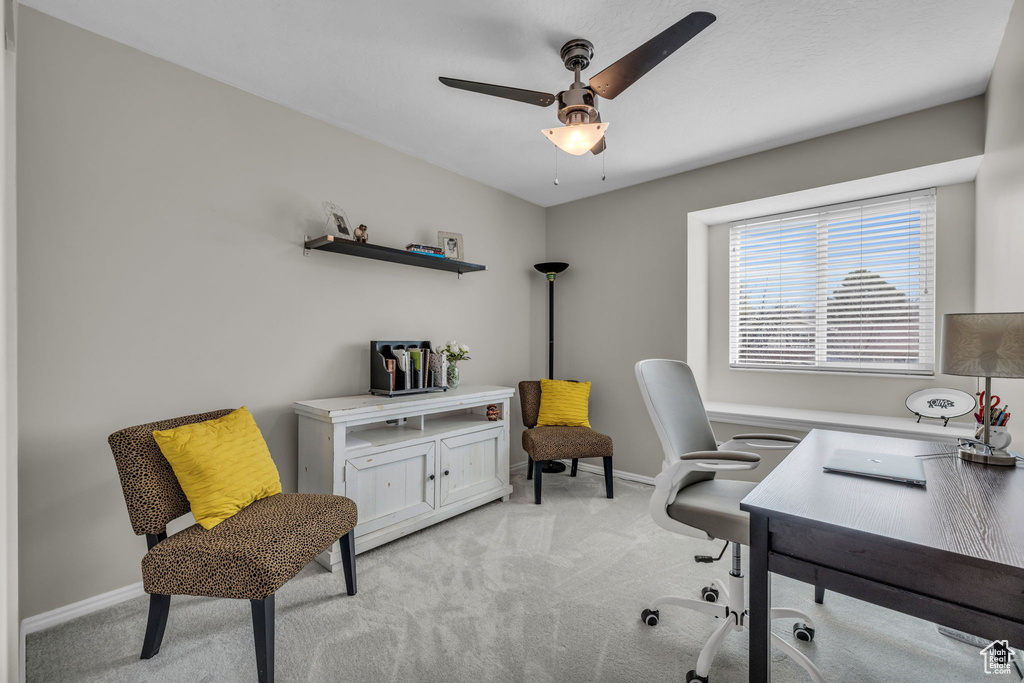 Home office with light colored carpet, baseboards, and ceiling fan