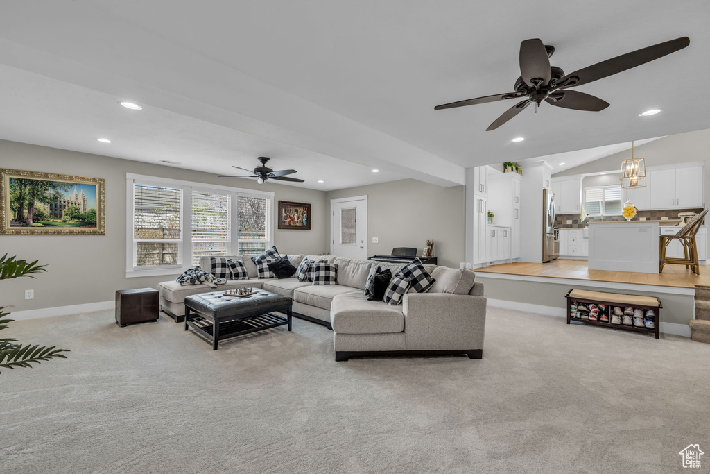 Living area with light colored carpet, baseboards, a ceiling fan, and recessed lighting
