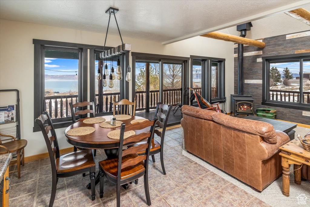 Dining room with baseboards, a wood stove, and lofted ceiling