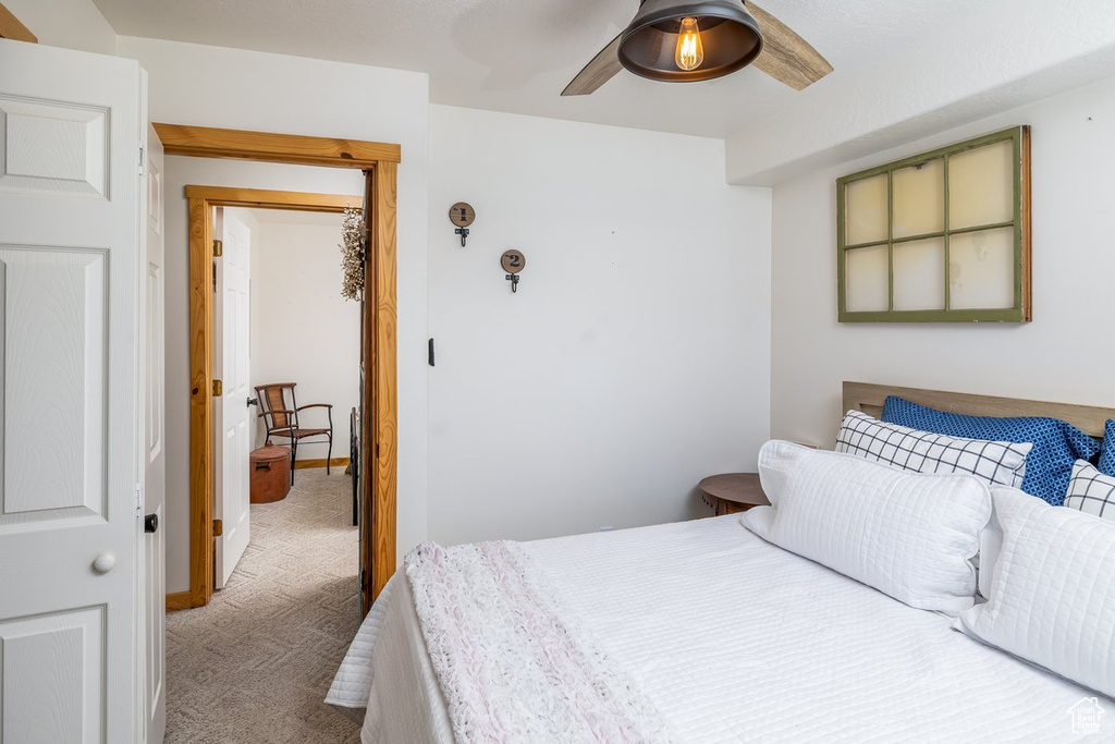 Carpeted bedroom with a ceiling fan