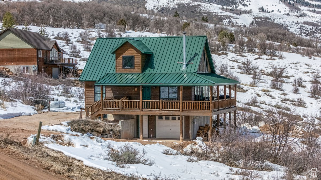 View of front of house featuring metal roof, a standing seam roof, and a garage