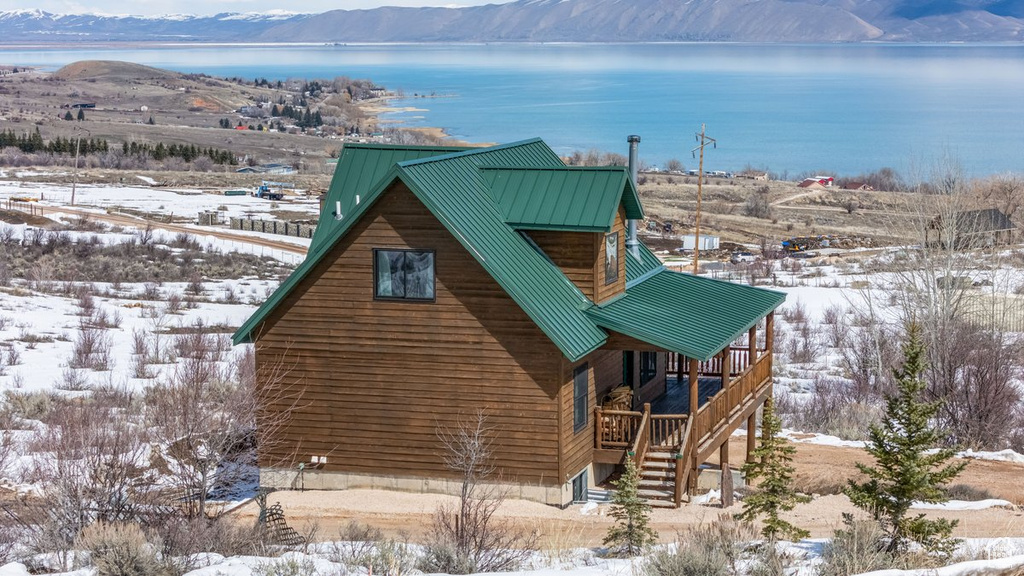 Exterior space featuring metal roof, a water and mountain view, and stairway