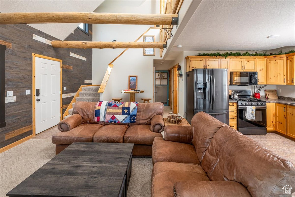Living room featuring a textured ceiling, light colored carpet, and stairway