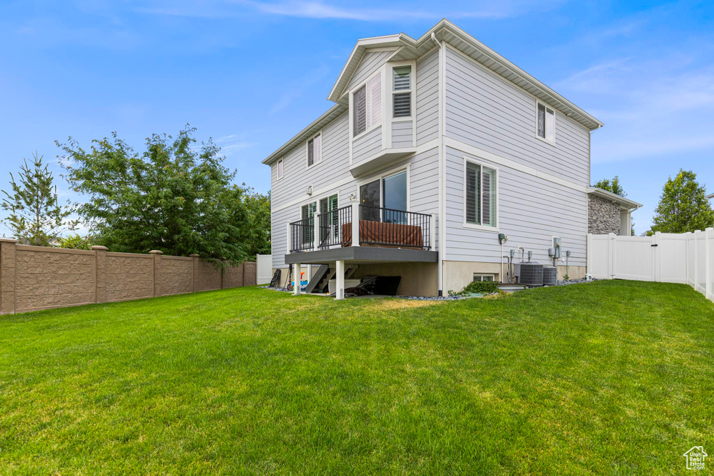 Back of property with central AC unit and a deck