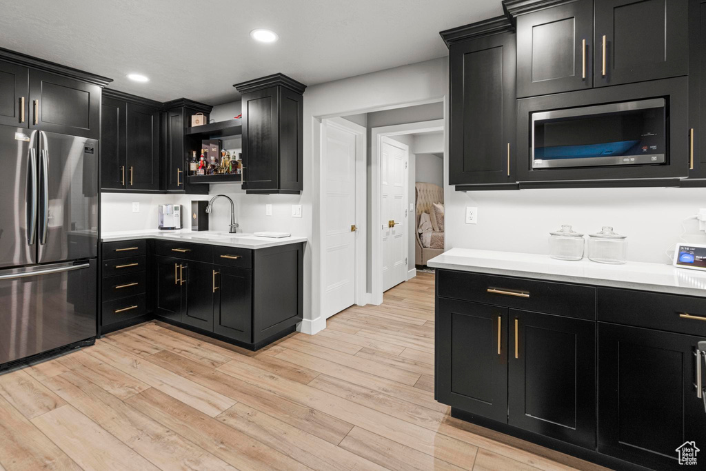 Kitchen featuring appliances with stainless steel finishes, dark cabinetry, light countertops, and recessed lighting
