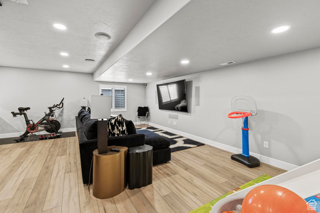 Exercise area featuring baseboards, wood finished floors, and recessed lighting