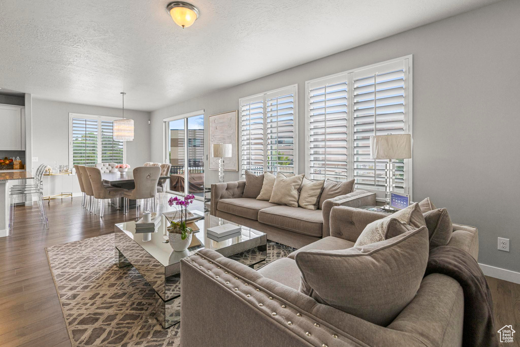 Living area featuring dark wood-type flooring, baseboards, and a textured ceiling