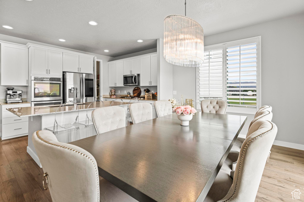 Dining area featuring wood finished floors, a chandelier, recessed lighting, and baseboards