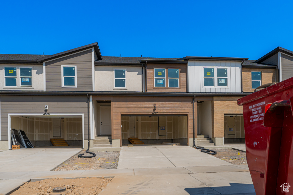 Multi unit property with entry steps, driveway, and an attached garage