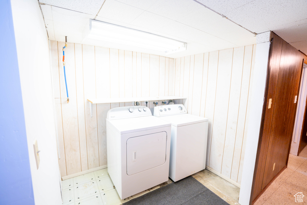 Laundry area with washer and clothes dryer and wooden walls
