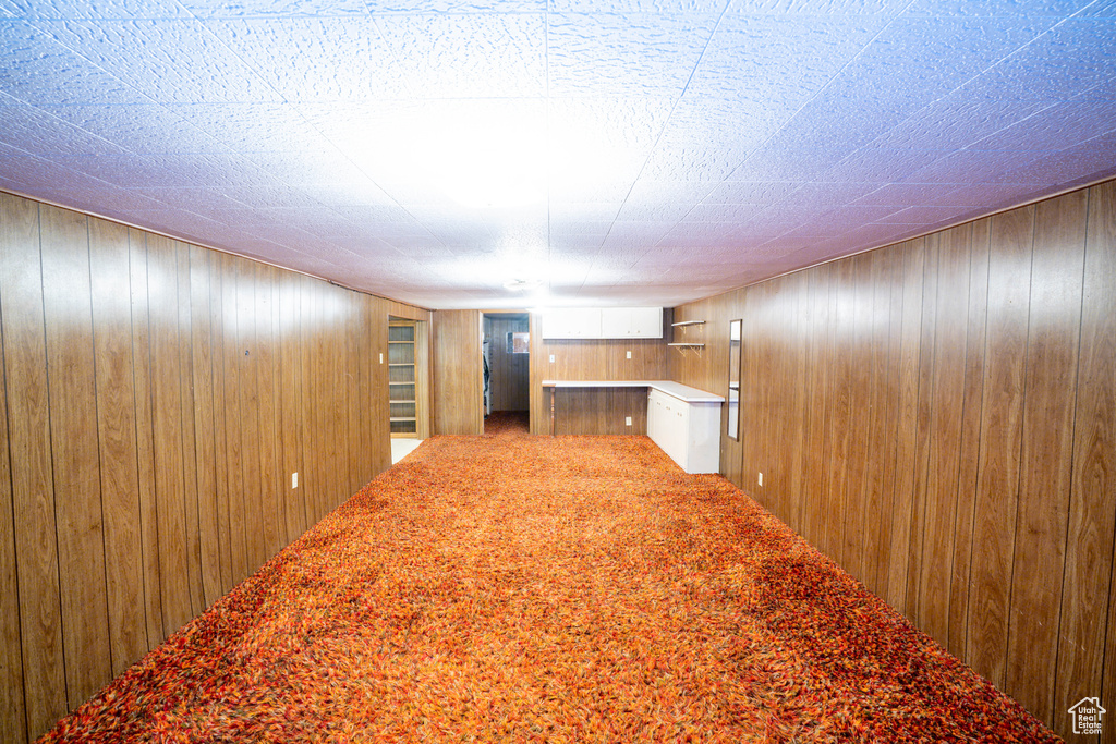 Hallway featuring wood walls