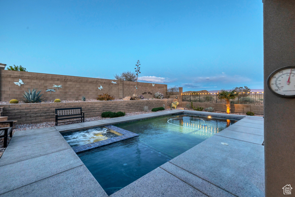 View of swimming pool with a patio area, a pool with connected hot tub, and a fenced backyard