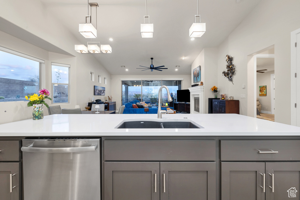 Kitchen featuring gray cabinets, open floor plan, dishwasher, and a sink