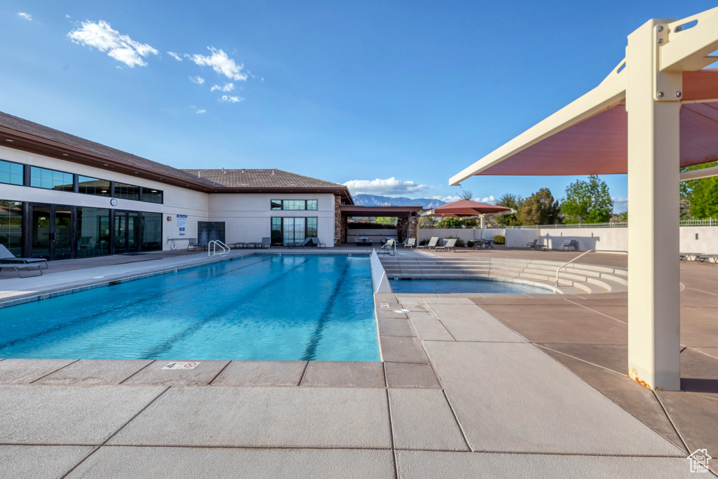 Pool with a patio area and fence