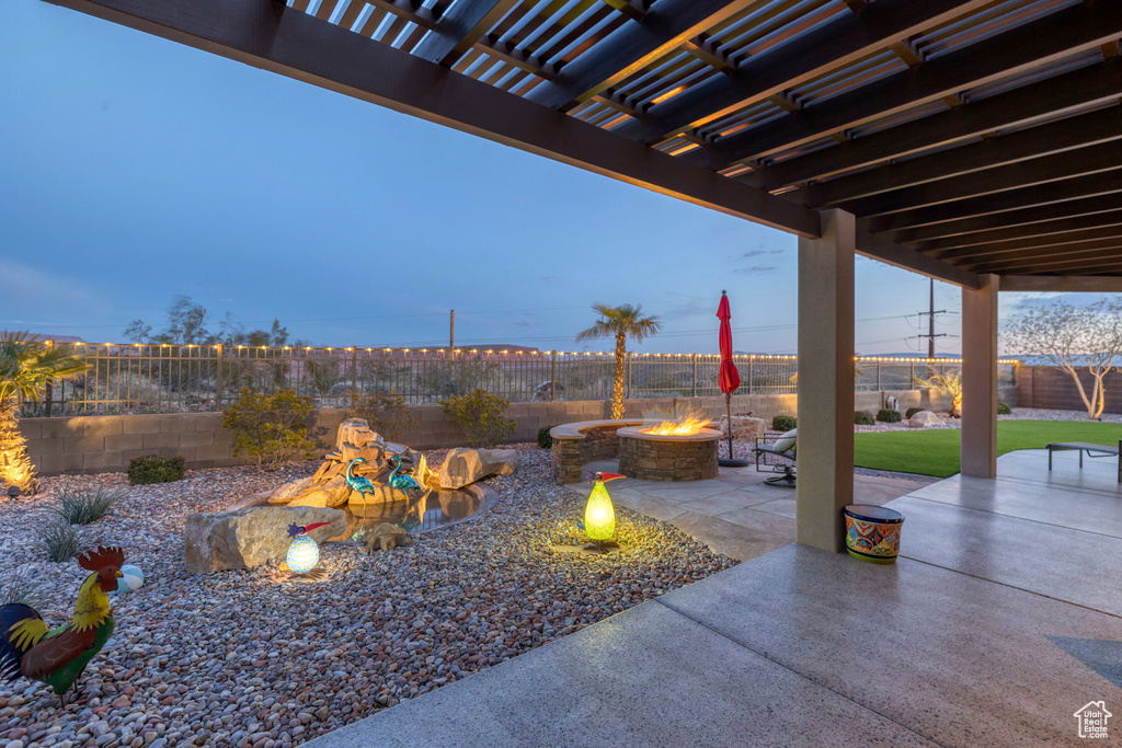 View of patio / terrace with a fenced backyard, a fire pit, and a pergola